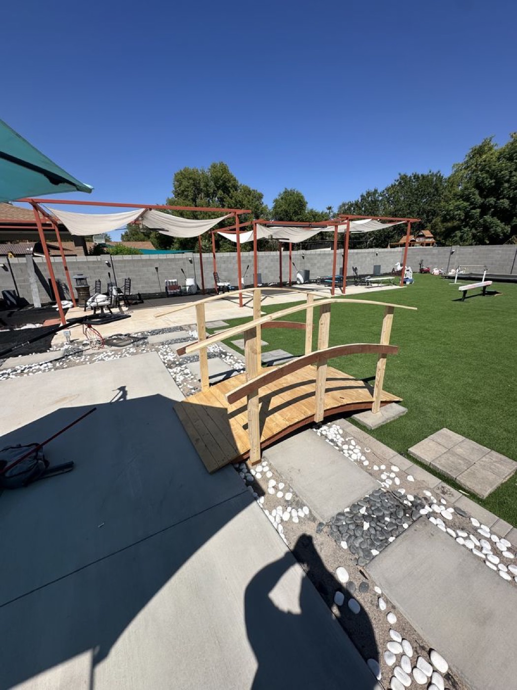 The wooden garden bridge in a landscaped backyard