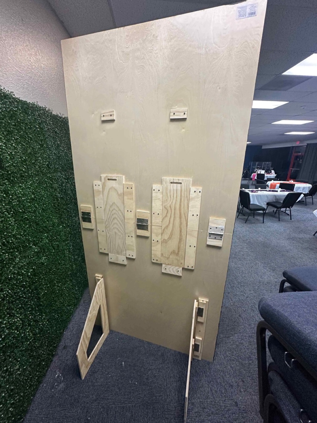 A custom plywood panel with hinged wood hardware built for an event space